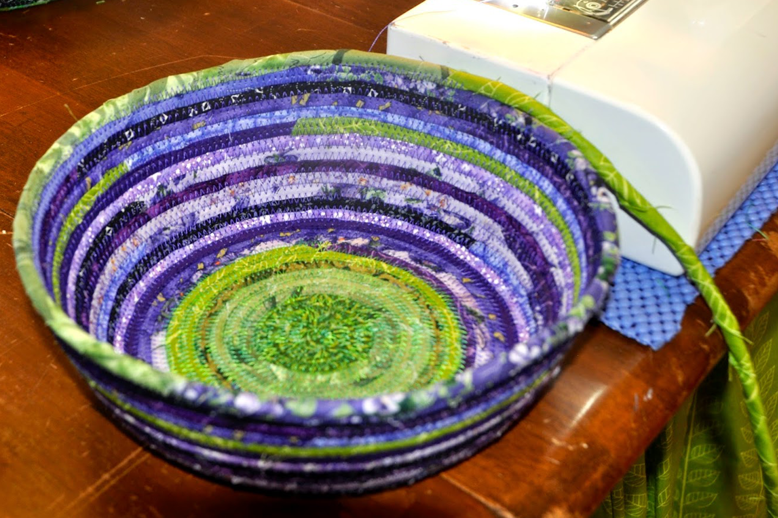 Coiled Fabric Bowls Happenings a fabric bowl is in progress next to a sewing machine